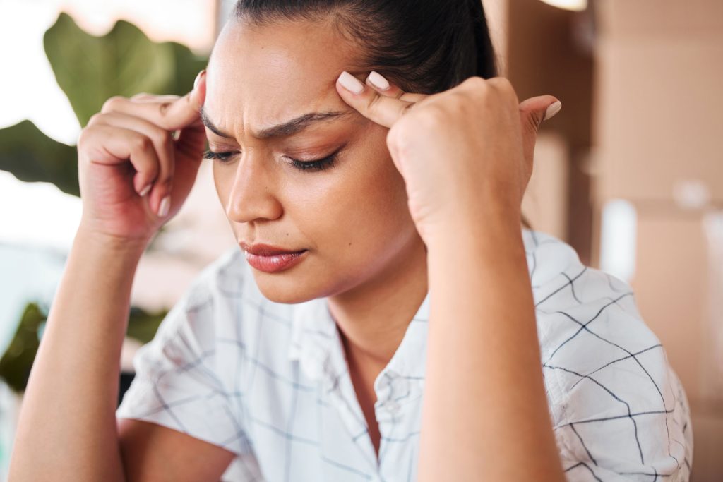 Woman holding her head due to headache.