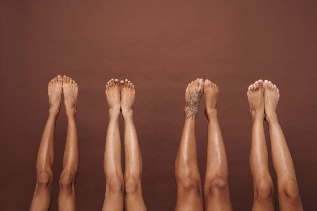 Four pairs of feet of african-american woman.