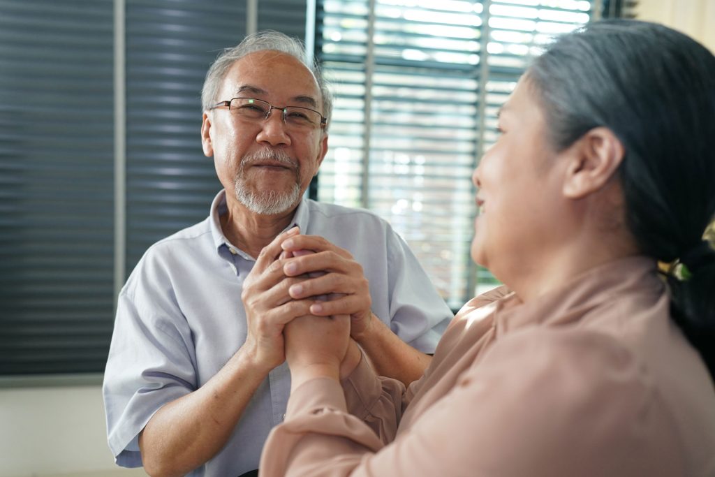 Man holding his wife's hand who has parkinson's disease.