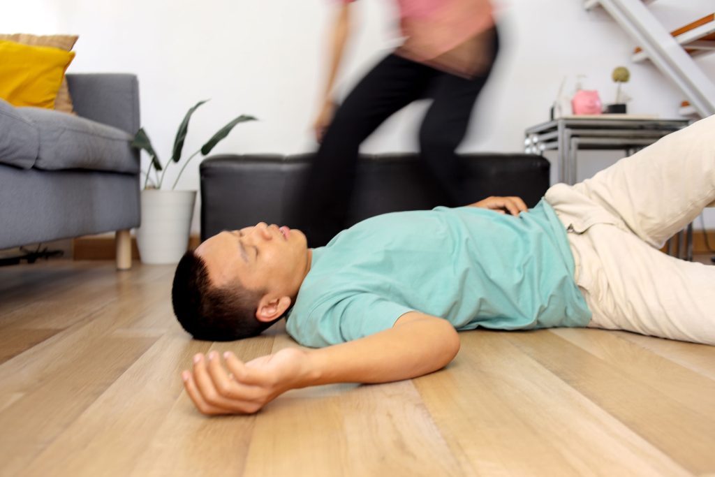 Woman running to husband who is having seizure.